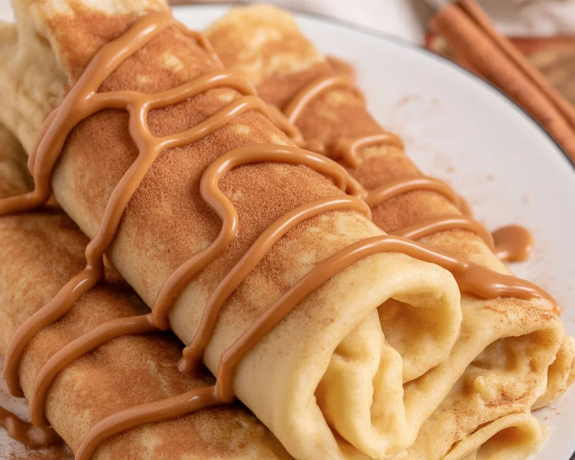 Delicious Cinnamon Roll Protein Crepes with a warm cinnamon filling and frosting