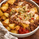 A delicious Smash Burger Bowl with fries, toppings, and special sauce in a cozy setting.